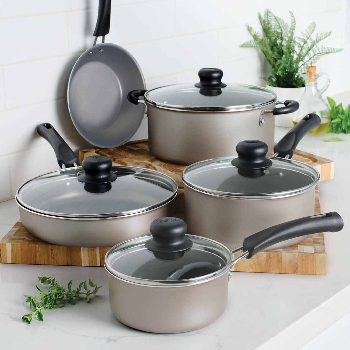 Set of cookware with lids on a kitchen counter and cutting boards