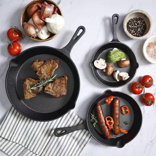 Cast iron skillets with steak, vegetables and sausages for everyday cooking