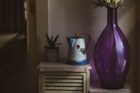 white and blue ceramic pitcher on brown wooden table