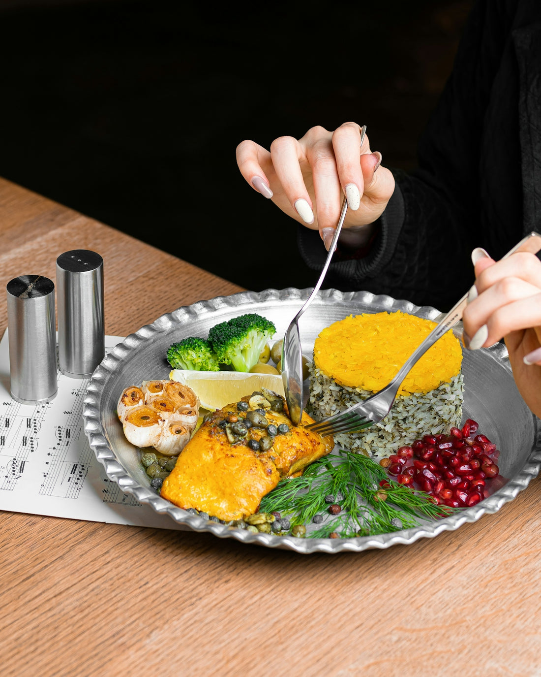 a woman is cutting into a plate of food