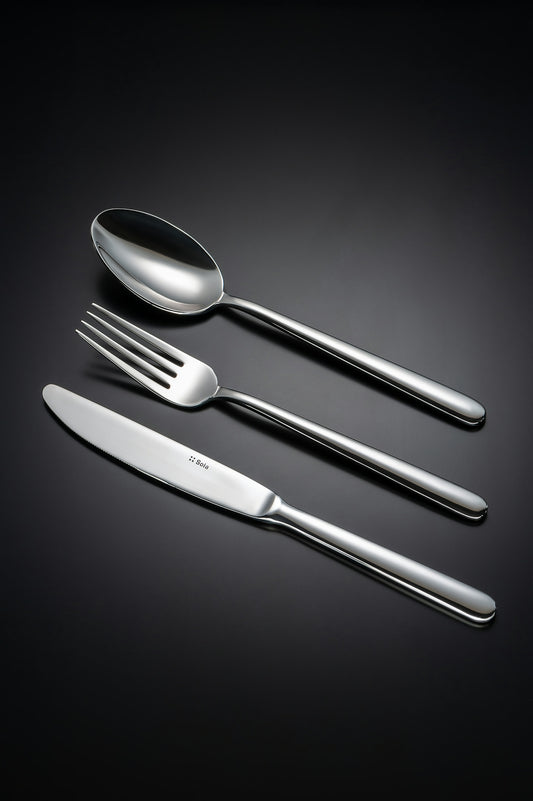 A spoon, fork, and knife on a black background.