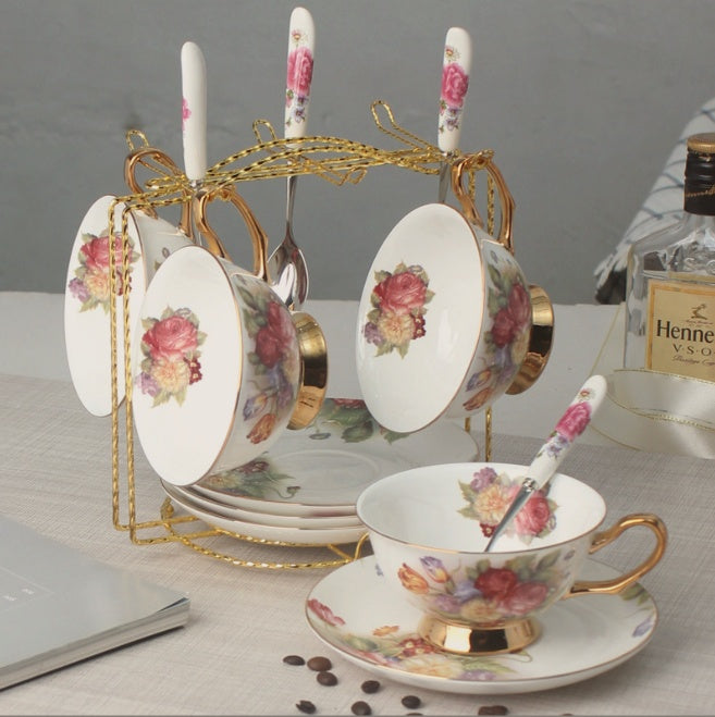 Tea set with floral design on a table with a bottle of Hennessy VSOP cognac.