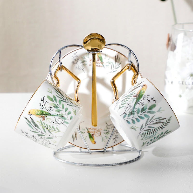 Set of three ceramic cups with decorative designs on a stand against a neutral background