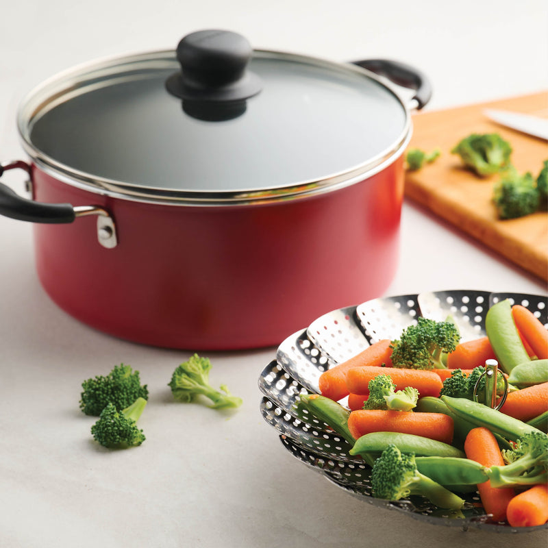 Red pot covered with glass lid and multifunction display accessory with carrots and peas