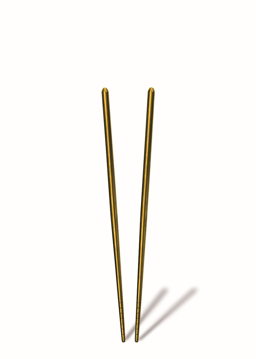 Pair of gold chopsticks on a white background