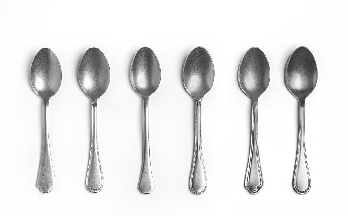 Set of six silver spoons on a white background