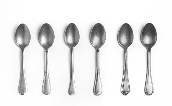 Set of six silver spoons on a white background