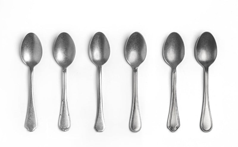 Set of six silver spoons on a white background