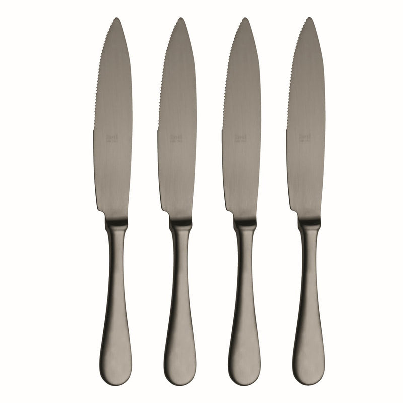 Four silver steak knives with serrated blades on a white background