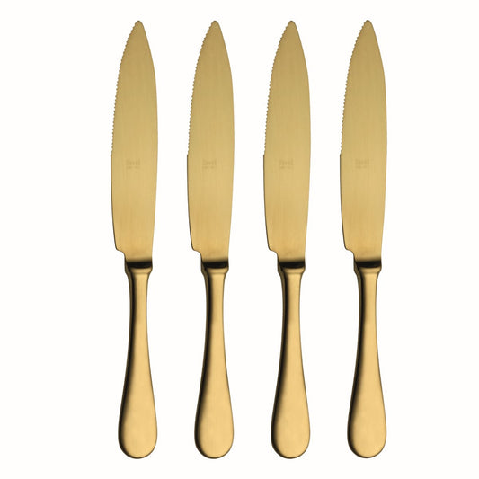 Four gold knives with serrated blades on a white background