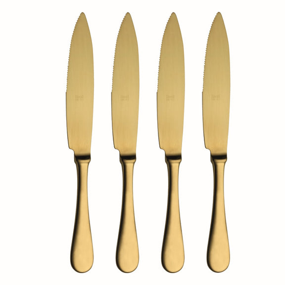 Four gold knives with serrated blades on a white background