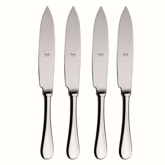 Set of four silver steak knives on a white background