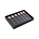 Set of rose gold spoons in a black box on a white background
