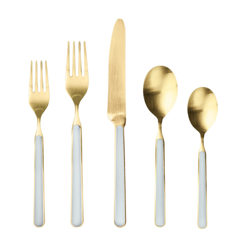 Set of gold cutlery with white handles on a white background