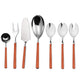 Set of silver cutlery with orange handles on a white background