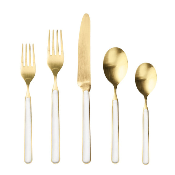 Set of gold cutlery with white handles on a white background