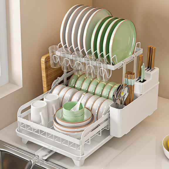 White dish rack with green and white dishes on a kitchen counter.
