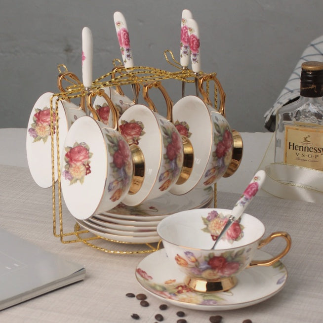 Set of floral teacups and saucers with a Hennessy VSOP cognac bottle in the background.