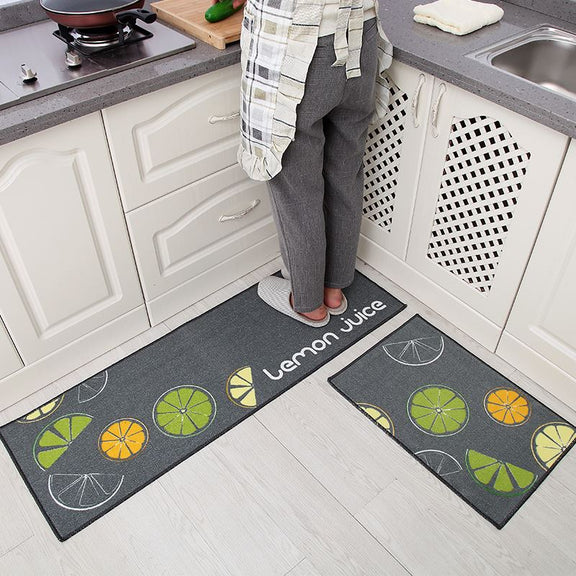 Two kitchen mats with lemon juice design on a kitchen floor.