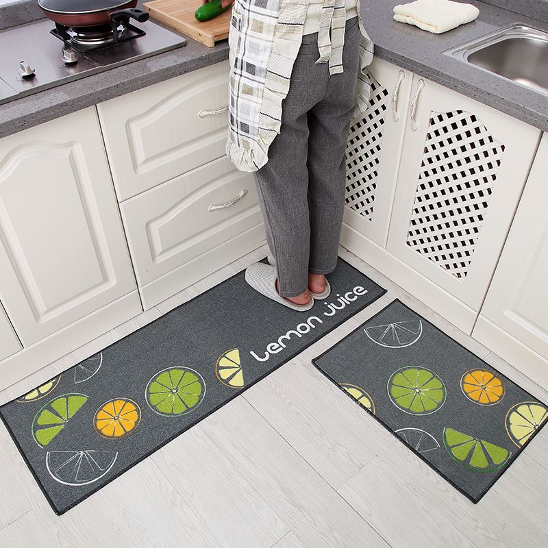 Two kitchen mats with lemon juice design on a kitchen floor.