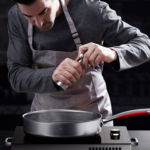 Person in a kitchen using a knife over a pot on a stove.
