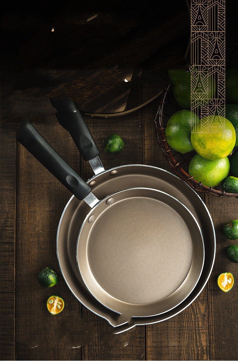 Set of metal cookware on a wooden surface with limes