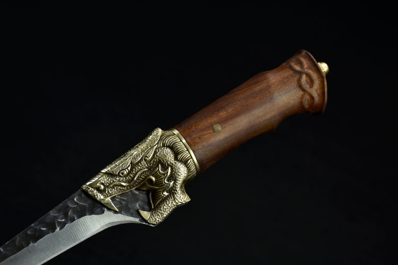 Decorative dagger with wooden handle and metal embellishments on a black background