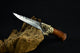 Decorative knife with a wooden handle and metal blade on a dark background
