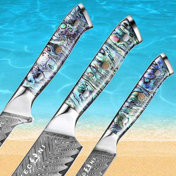 Three knives with decorative handles on a beach and ocean background