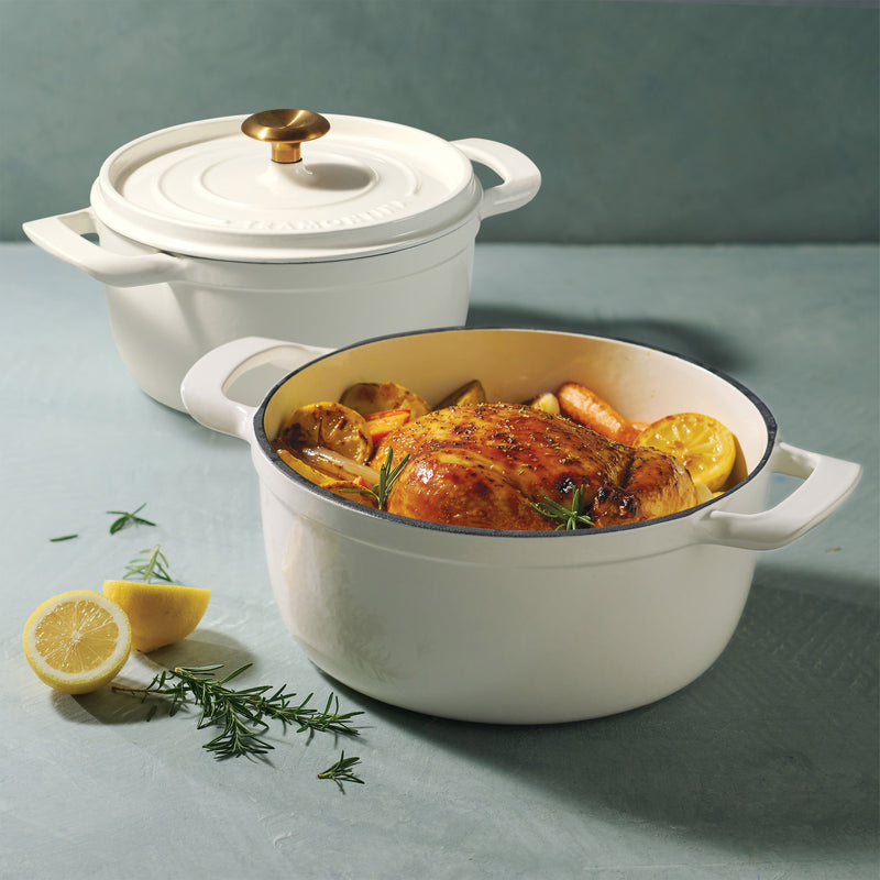 White ceramic cookware with a roasted chicken dish on a light blue background