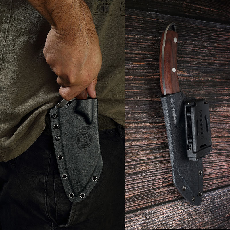 Knife in a sheath held by a person and another knife on a wooden surface.