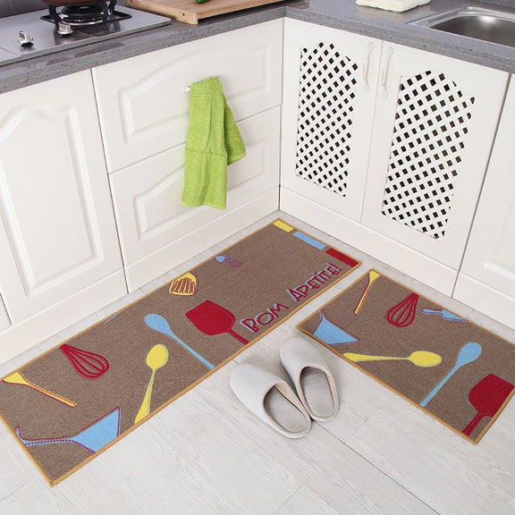 Two kitchen mats with colorful utensil designs on a white floor.