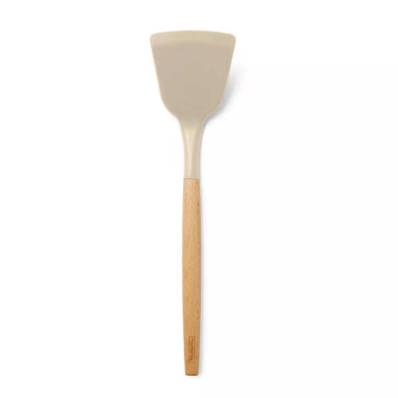Spatula with beige silicone head and wooden handle on a white background