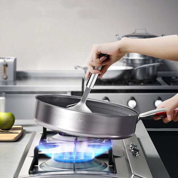 Person holding a frying pan over a gas stove in a kitchen