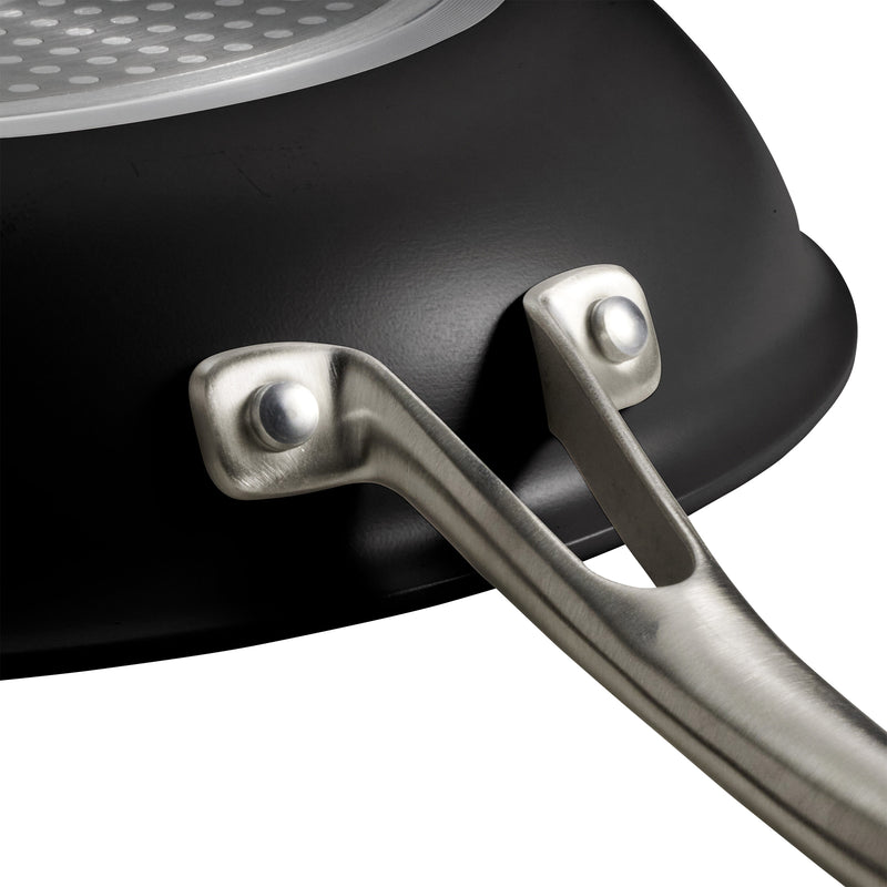 Close-up of a black frying pan with a silver handle on a white background