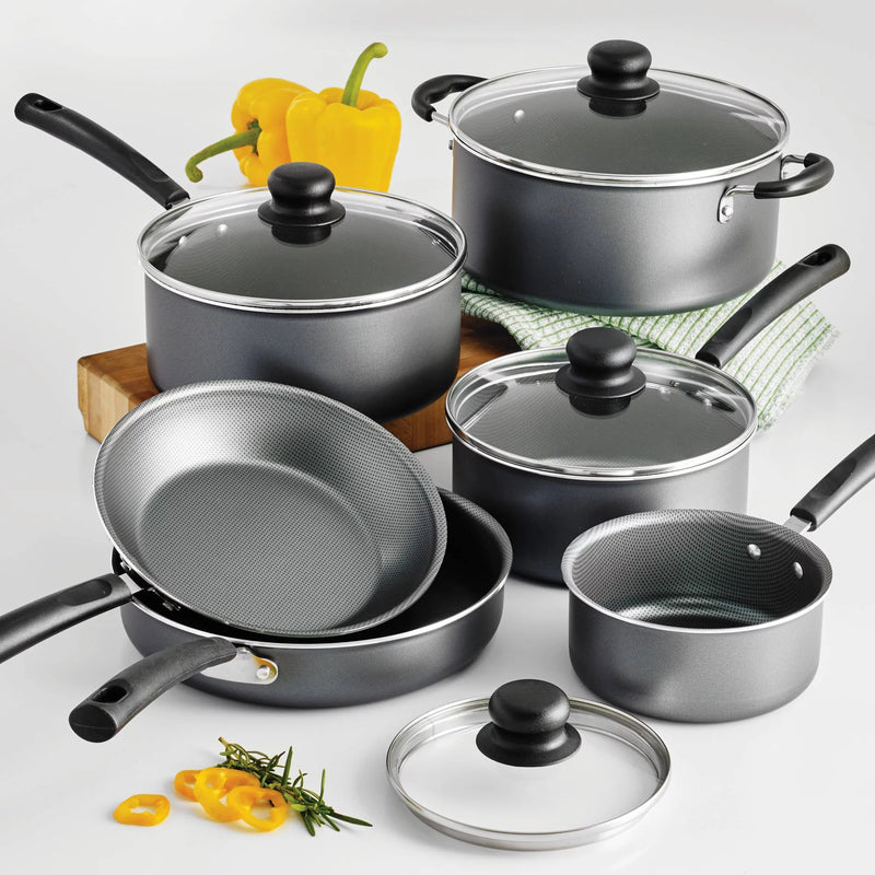 Set of gray cookware with black handle and clear glass lids on a white background