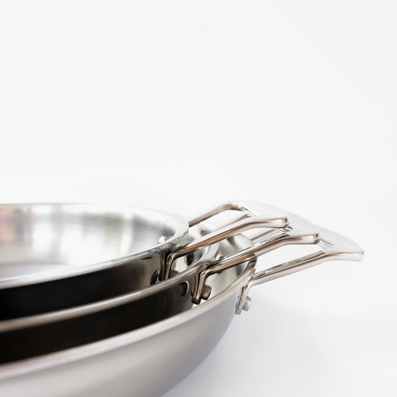Close-up of a stack of stainless steel cookware on a white background