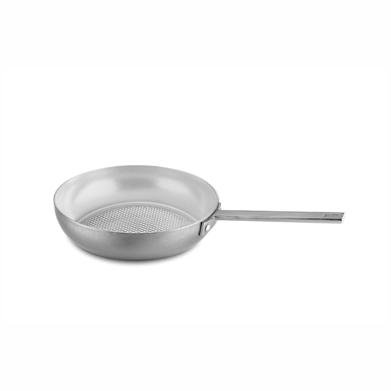 Stainless steel frying pan with perforated bottom on a white background