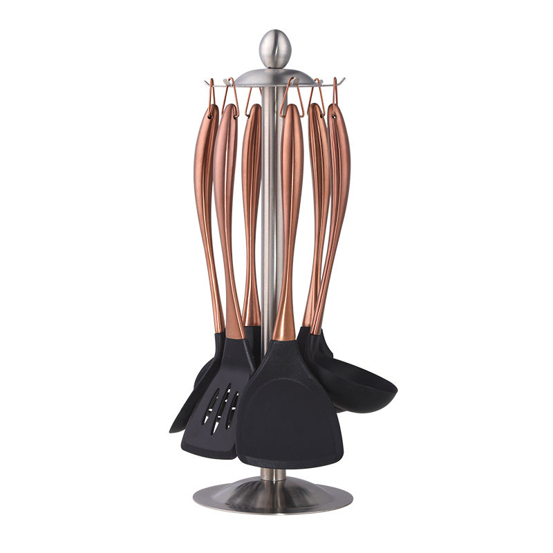 Set of kitchen utensils with black bottoms and rose gold handles on a white background