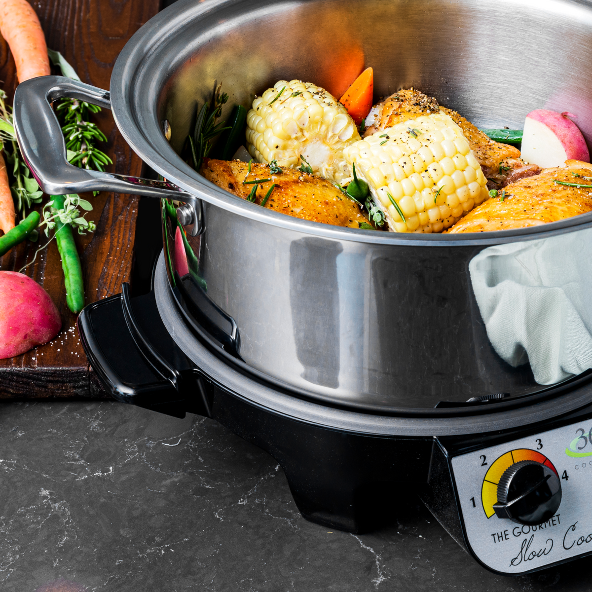 Stainless steel slow cooker with food on a dark surface