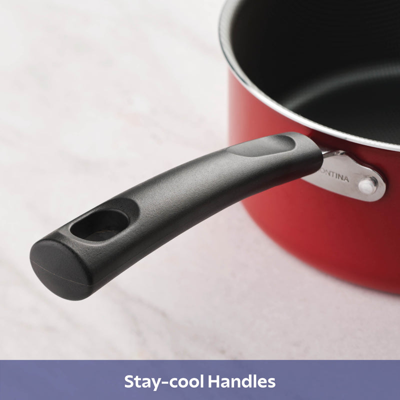 Closeup of red pot with black stay cool handles on white background