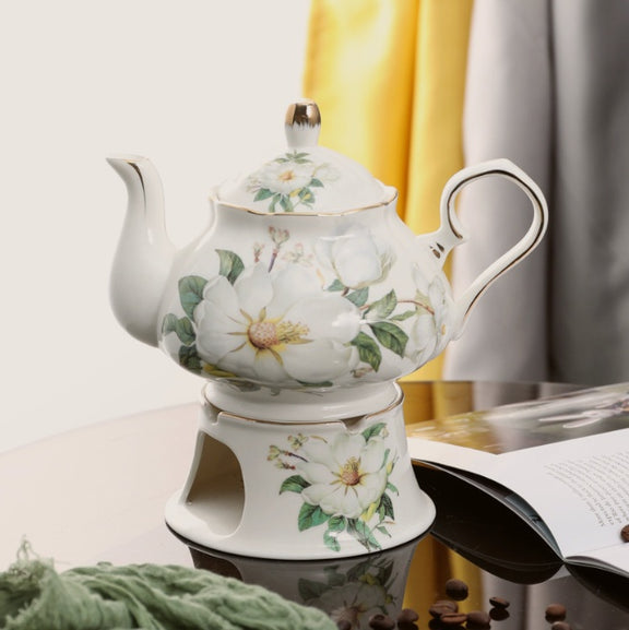 Decorative ceramic teapot with floral design on a white background