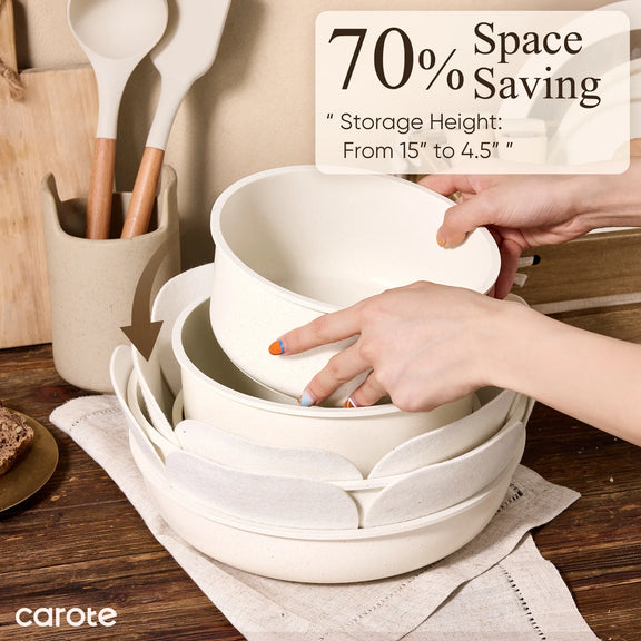 Stack of white bowls with a hand reaching for one, on a wooden surface with kitchen utensils in the background.
