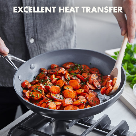 Person cooking carrots in a greenpan pan with text 'Excellent Heat Transfer'.