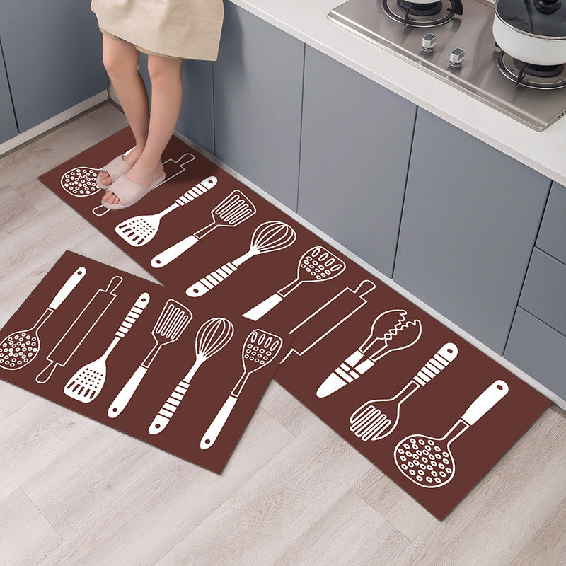Kitchen mat with cooking utensil designs on a wooden floor.