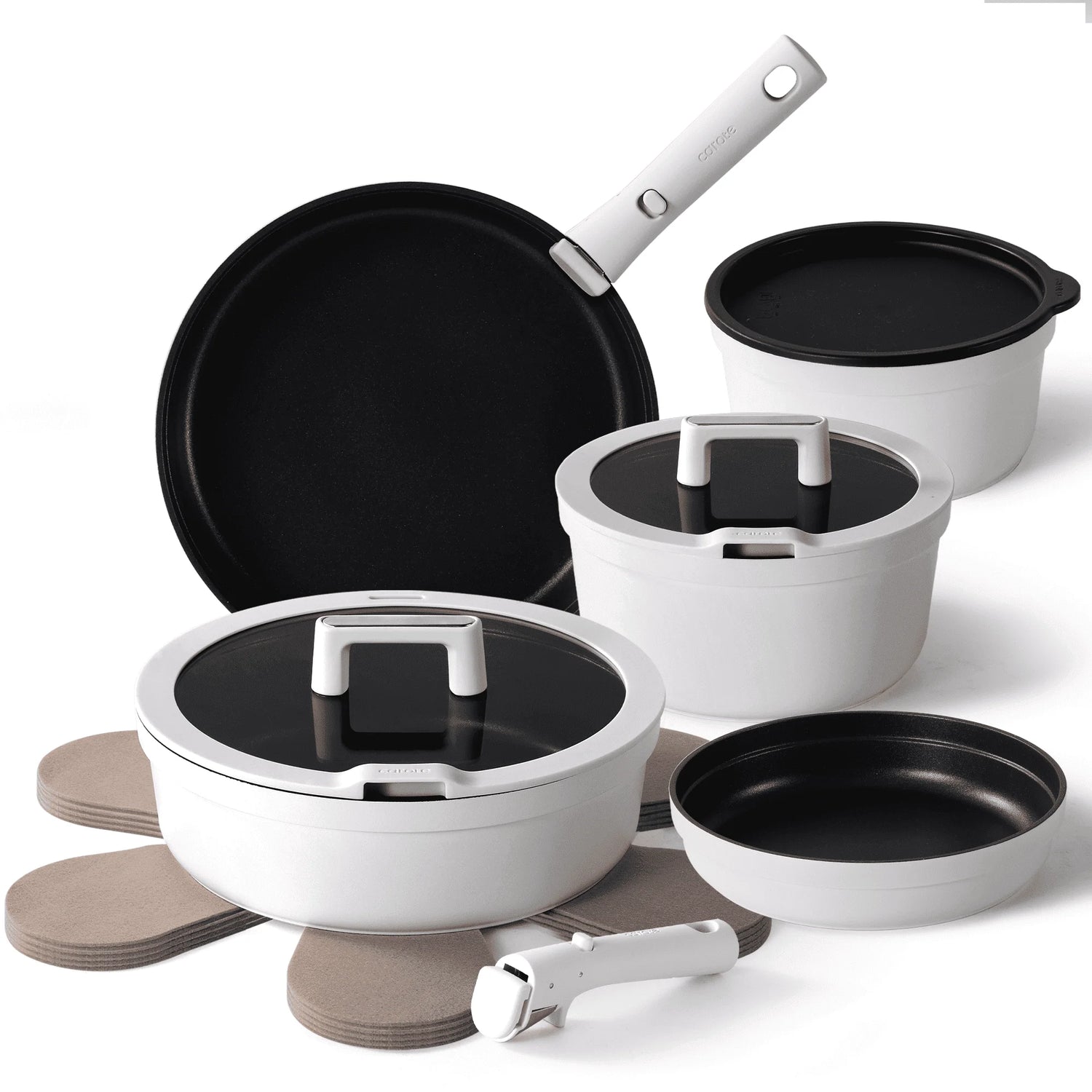 Set of cookware including pots, pans, and lids on a white background