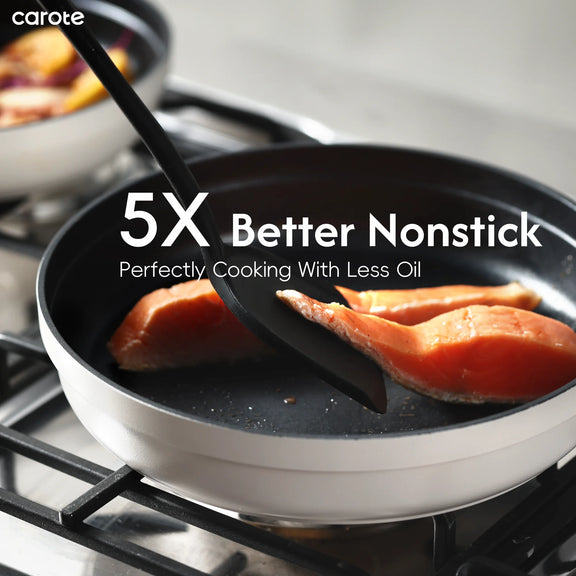 Frying pan with salmon being cooked on a stove, featuring carote brand text.