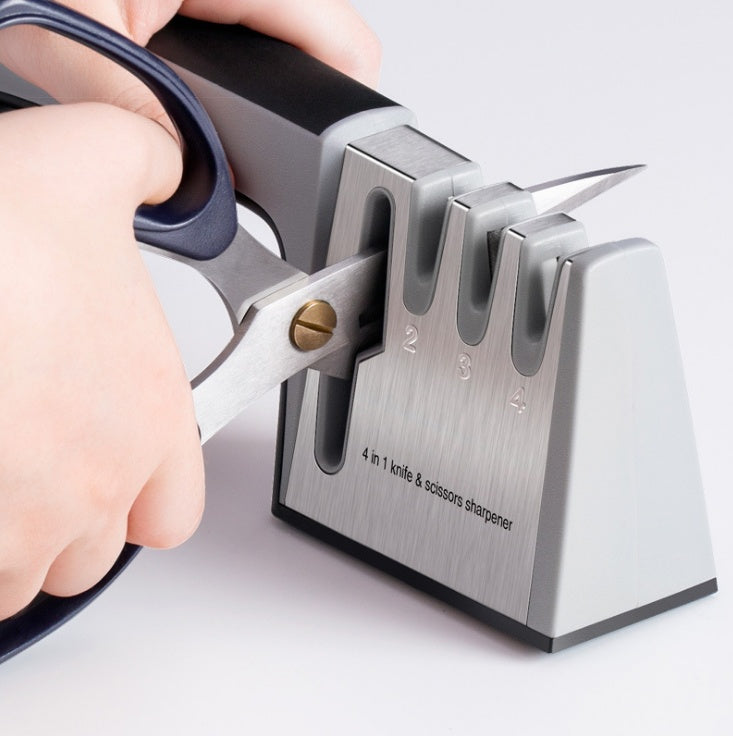 Knife sharpener with a hand holding a pair of scissors, on a light gray background