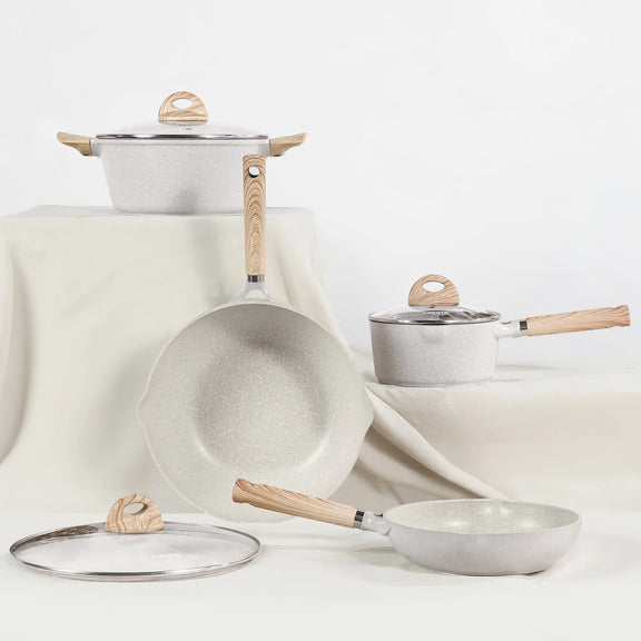 Set of cookware with wooden handles on a light background