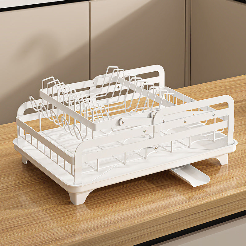 White dish rack on a wooden countertop with beige cabinets in the background